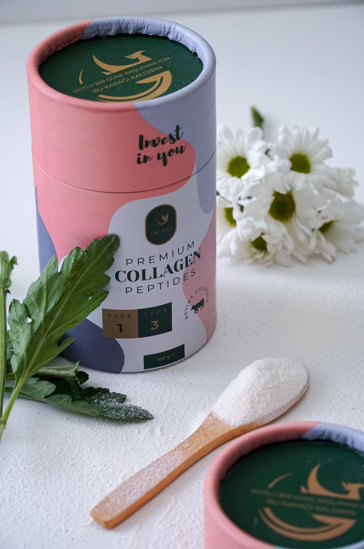 pote de colágeno em pó ao lado de flores brancas