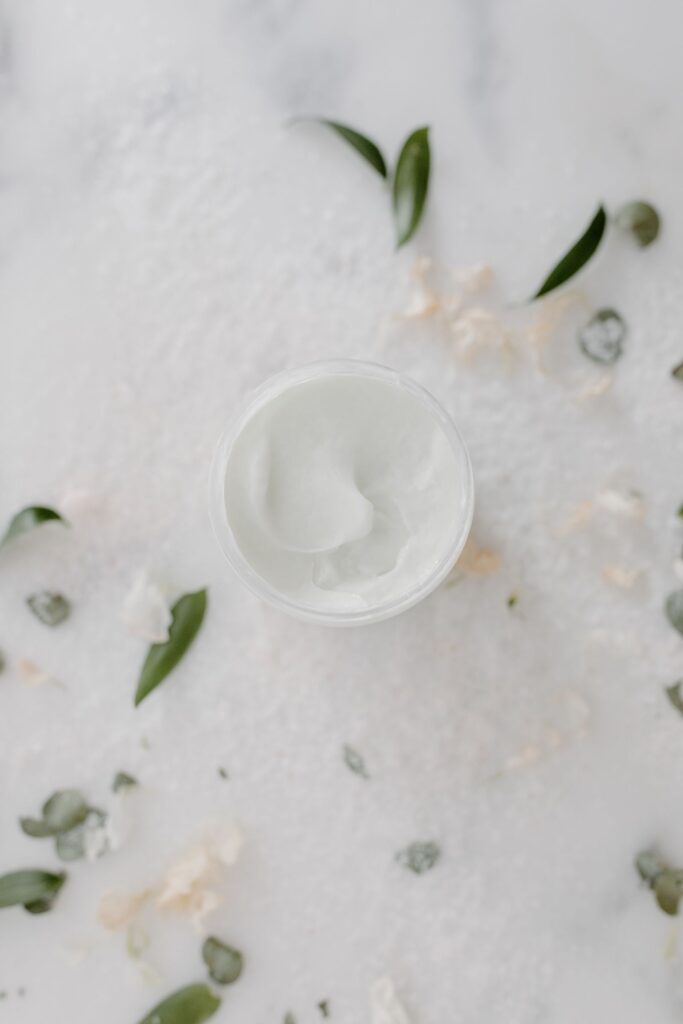 Pote de creme hidratante entre folhas