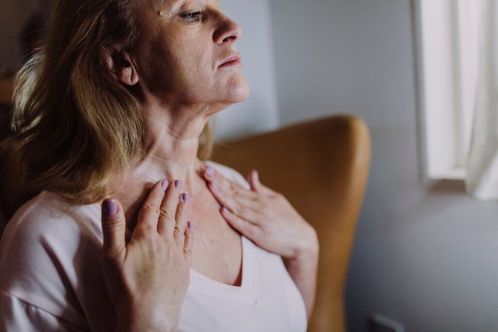 Mulher madura massageando o pescoço e colo na rotina de skincare com gluconolactona