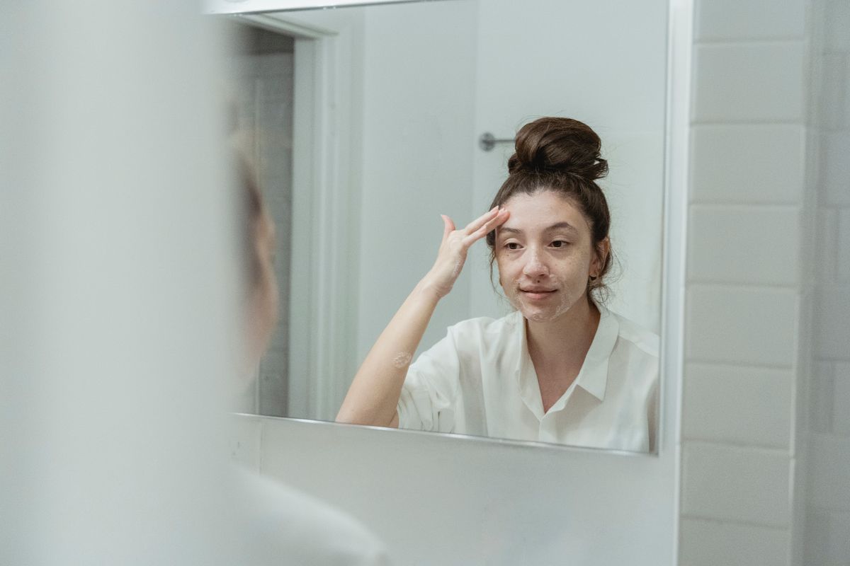 mulher madura aplicando creme para fortalecer a barreira e o microbioma da pele