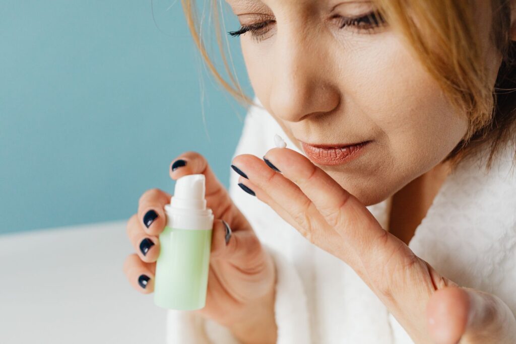 Mulher aplicando sérum reparador com pantenol no rosto