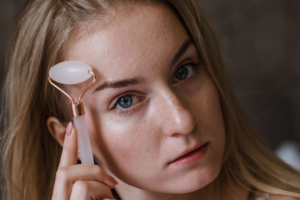 rolo de massagem facial gua sha e quartzo sendo usado no rosto