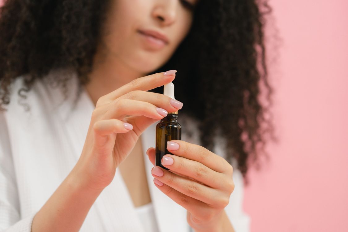 Sérum e ampola: frasco de sérum com conta-gotas sendo segurado