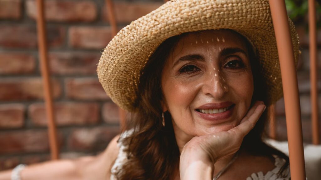Mulher madura sorrindo com chapéu de palha ao ar livre