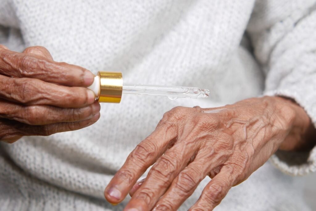 Mulher madura aplicando produto hidratante nas mãos