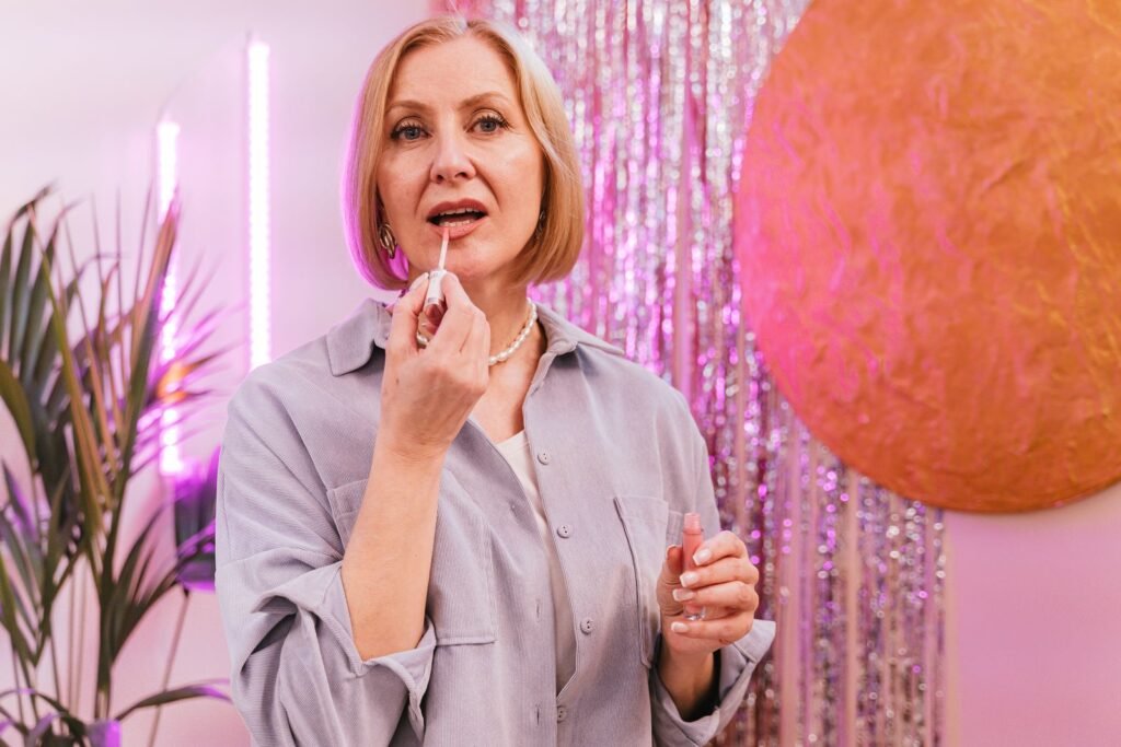 Mulher madura aplicando produto nos lábios