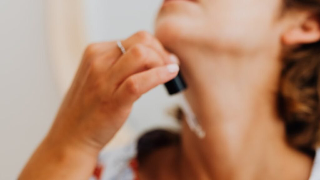 Mulher madura aplicando sérum com conta-gotas no pescoço