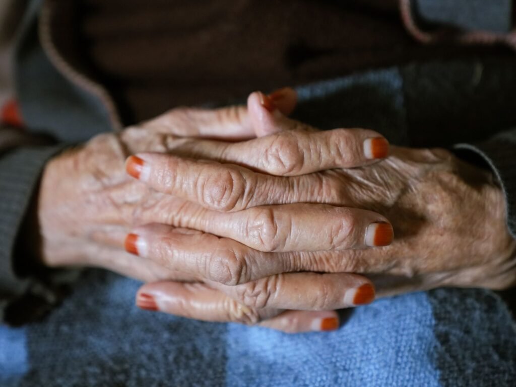 Unhas fracas: mãos de mulher madura entrelaçadas